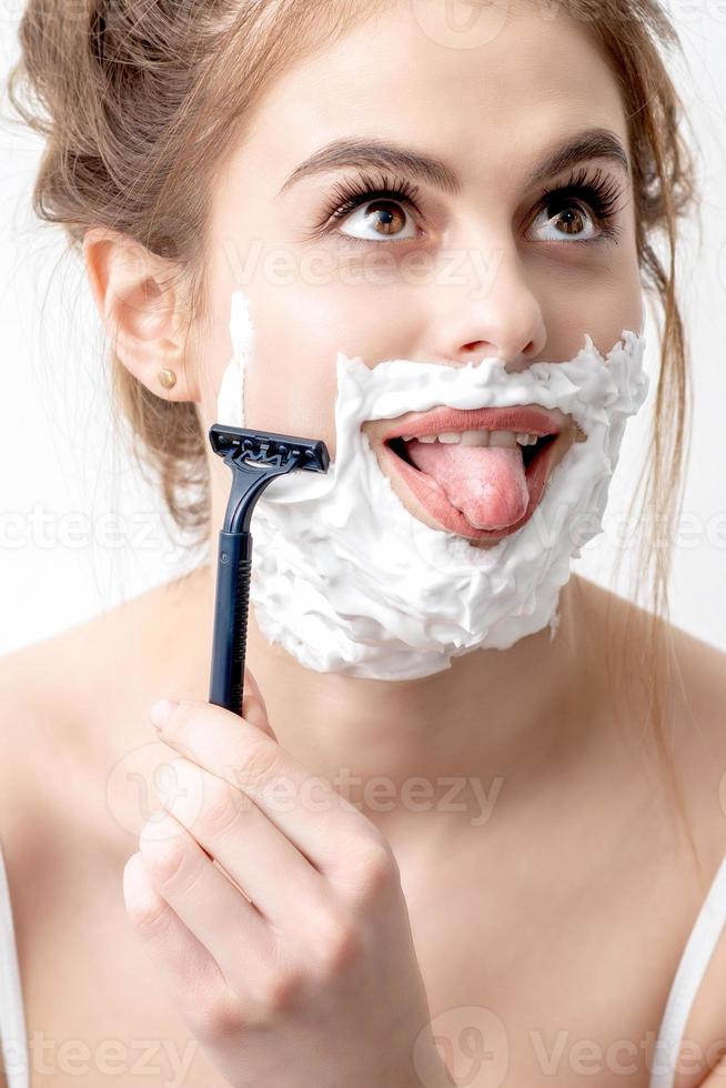femme se rasant le visage au rasoir photo