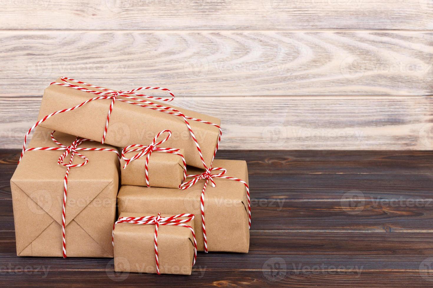 pile de coffrets cadeaux artisanaux sur planche de bois avec un fond texturé naturel photo