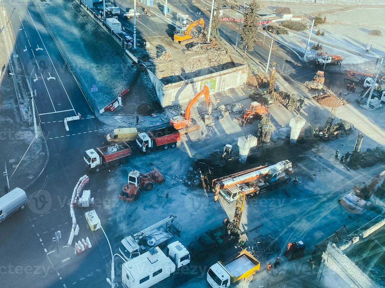 construction d'un nouveau viaduc au centre-ville sur une rue enneigée. réfection de la route du centre-ville, aménageant le chemin pour les engins de chantier et les personnes photo