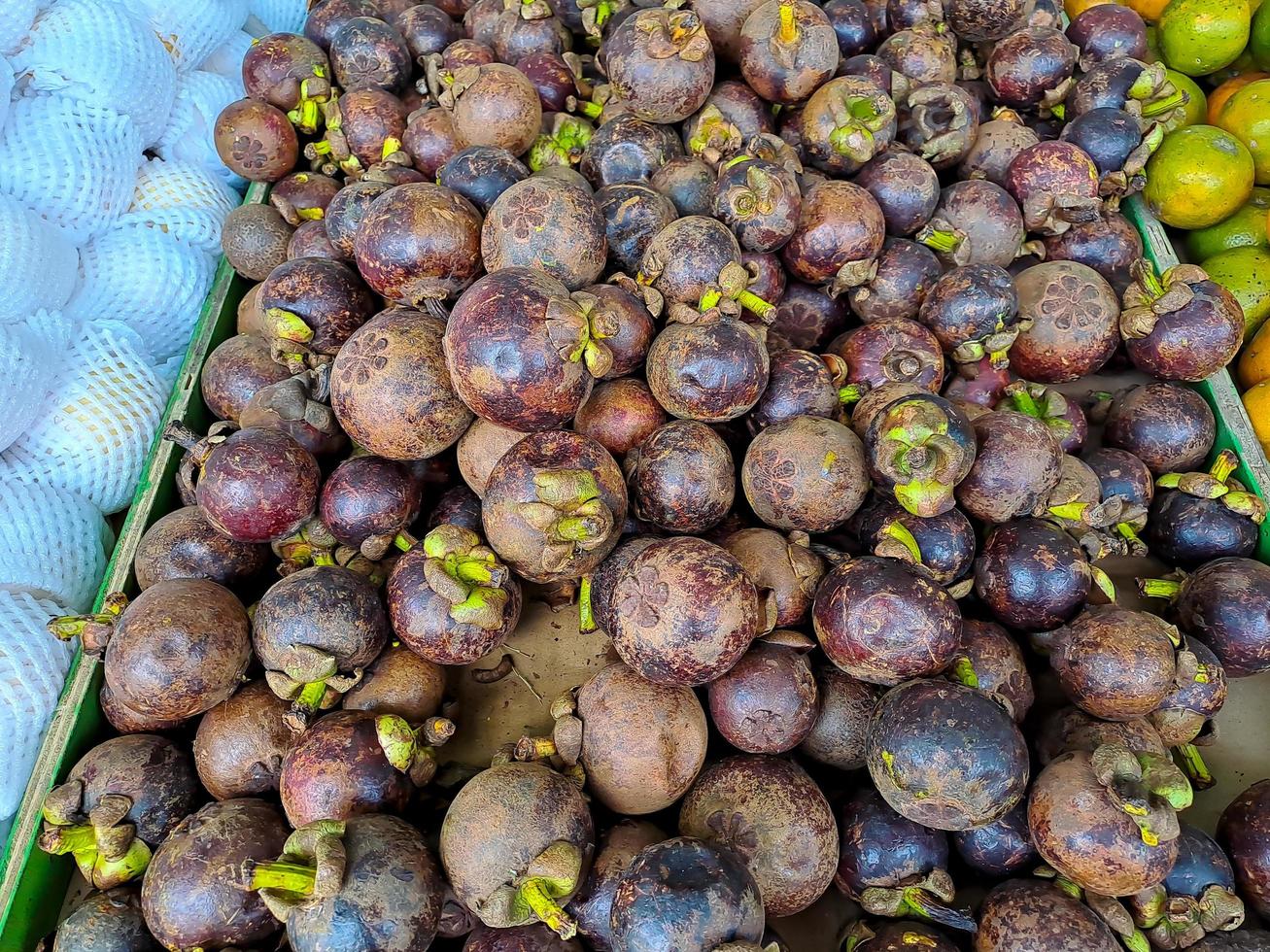 bouquet de mangoustan violet doux, plusieurs fruits mis sur une table en bois sur fond naturel à vendre photo