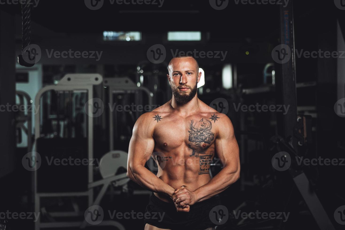 homme de fitness montrant ses muscles à la salle de gym photo