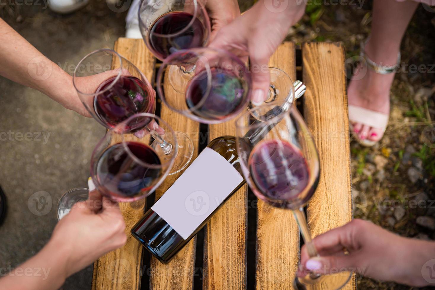 les gens trinquent avec du vin sur la terrasse d'été du café ou du restaurant photo