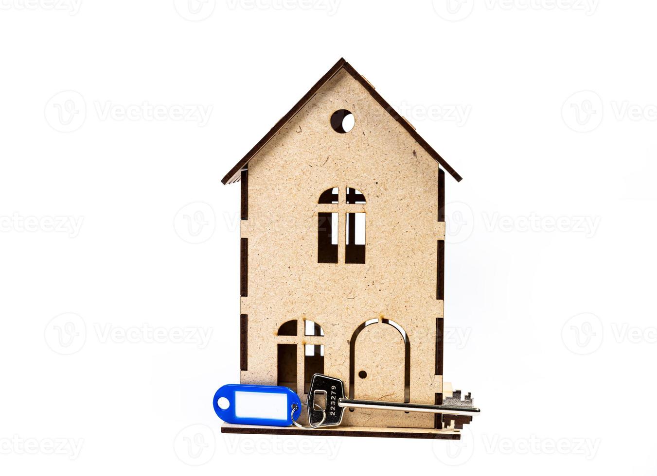 symbole de la maison avec clé en métal sur fond blanc. immobilier, concept d'assurance, hypothèque, achat de maison de vente, concept d'agent immobilier photo