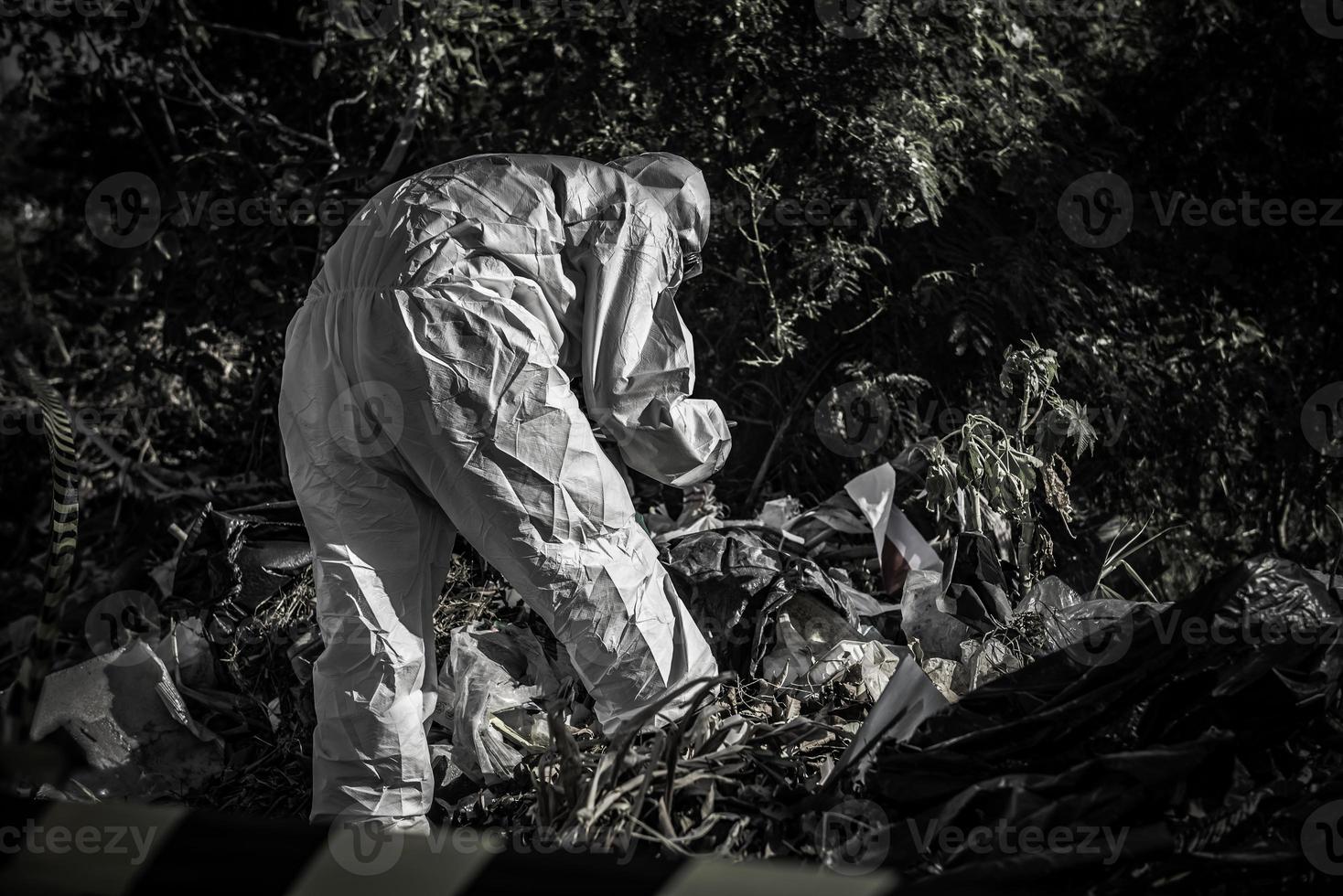 scientifique asiatique porter une combinaison de protection chimique vérifier le danger chimique, travailler dans une zone dangereuse photo