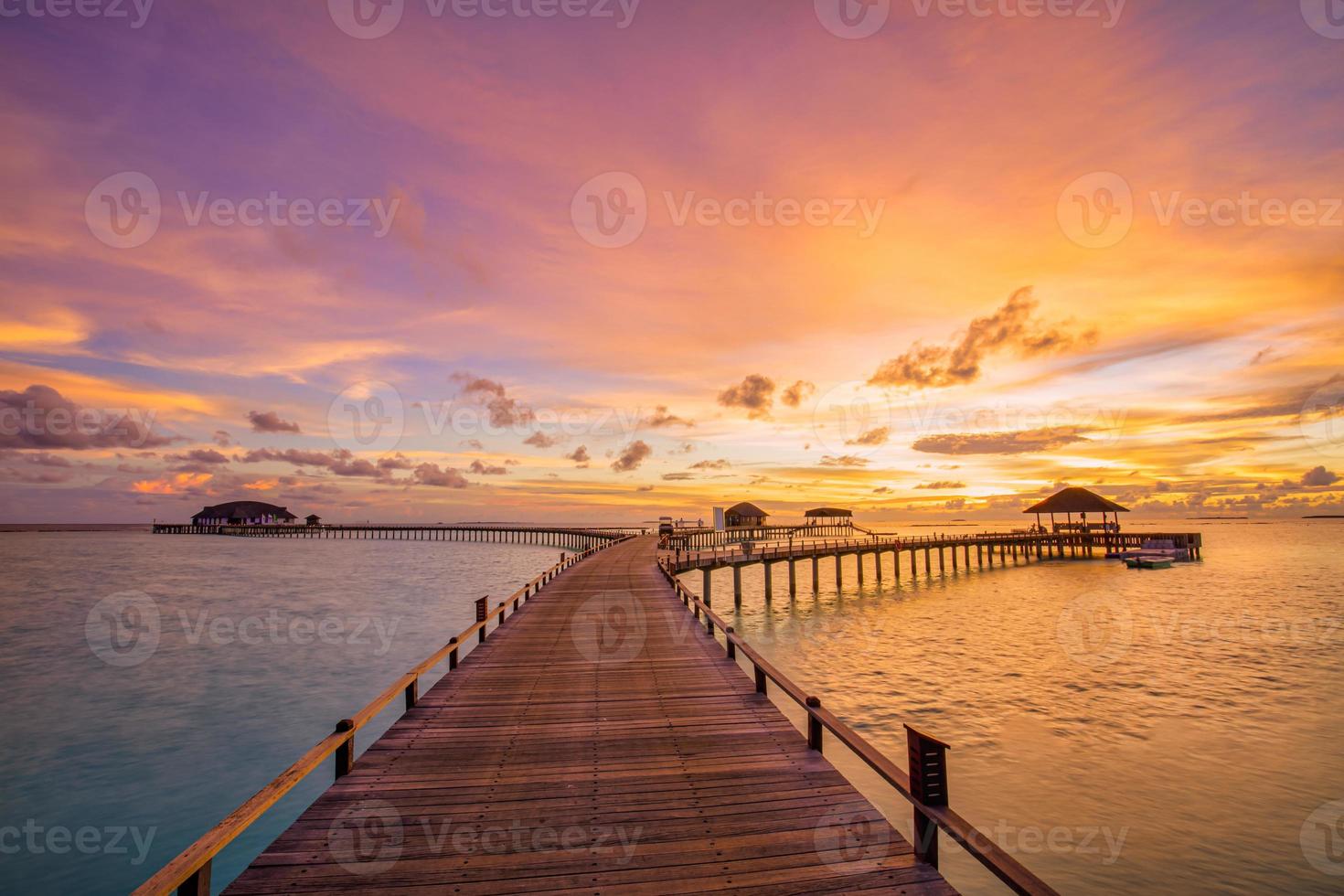 magnifique coucher de soleil paradisiaque des maldives. paysage aérien tropical, paysage marin, villas sur l'eau ciel de mer incroyable, plage de lagon, nature tropicale. destination touristique exotique, vacances aériennes d'été, vue sur drone. photo