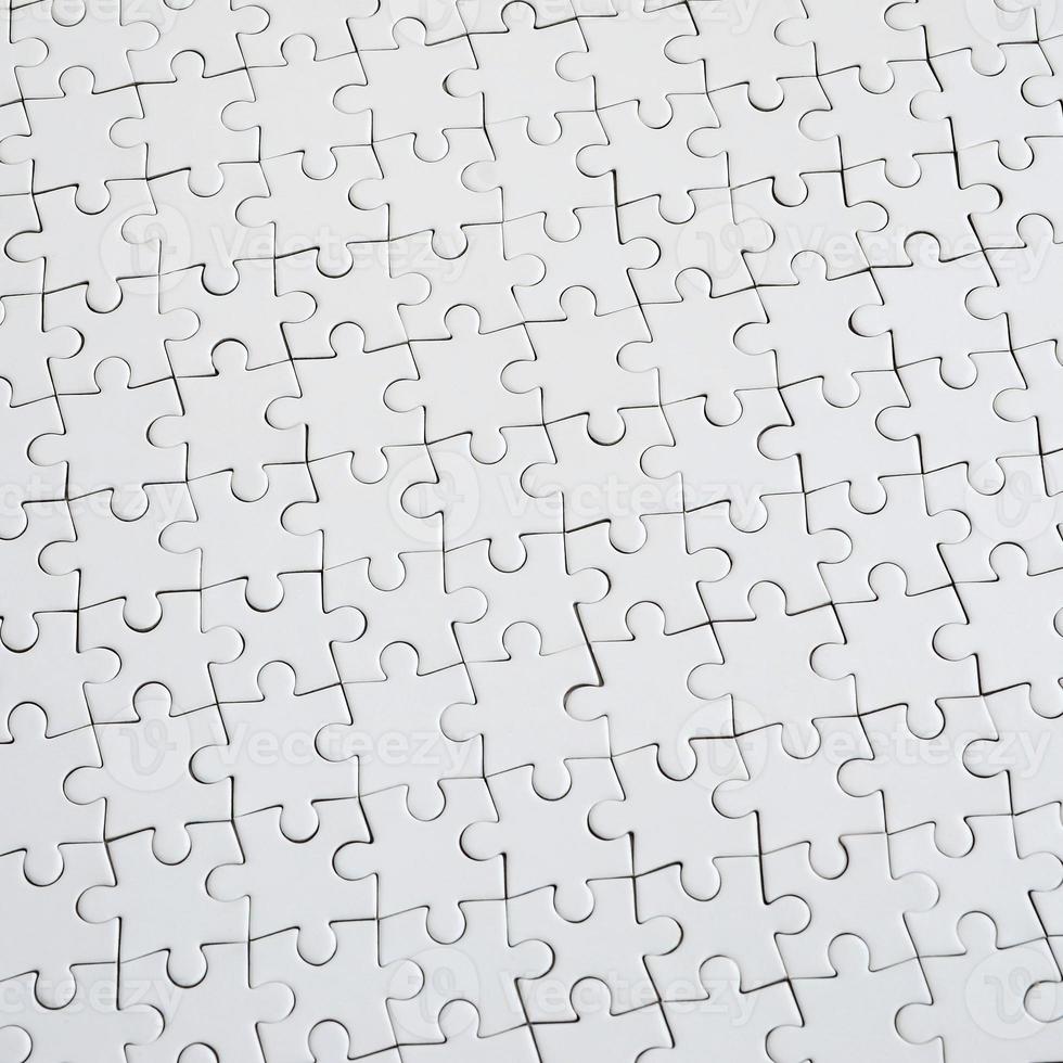 Close up texture d'un puzzle blanc à l'état assemblé. vue de dessus. de nombreux composants d'une grande mosaïque entière sont unis photo