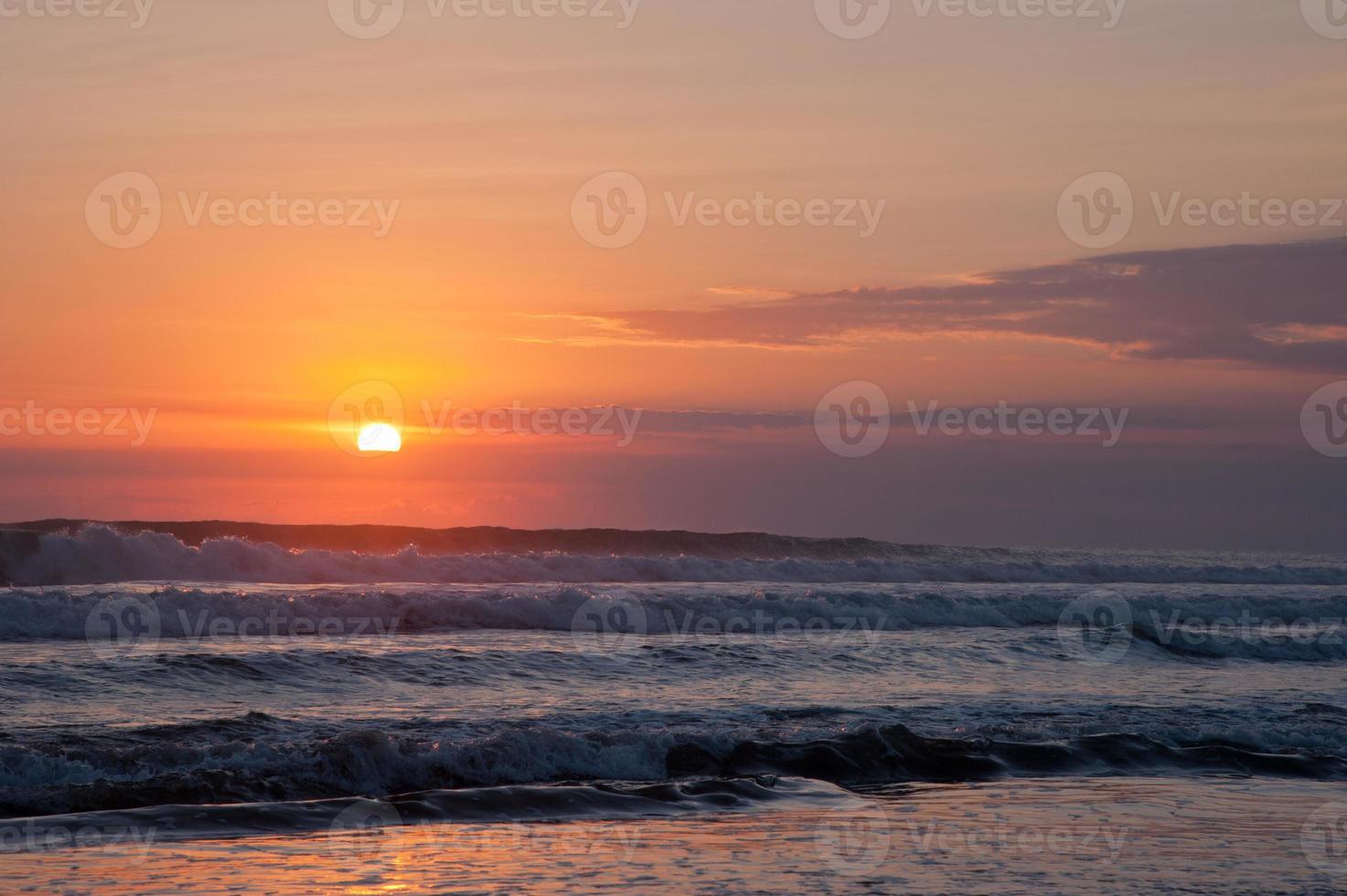 belles vagues au coucher du soleil orange photo