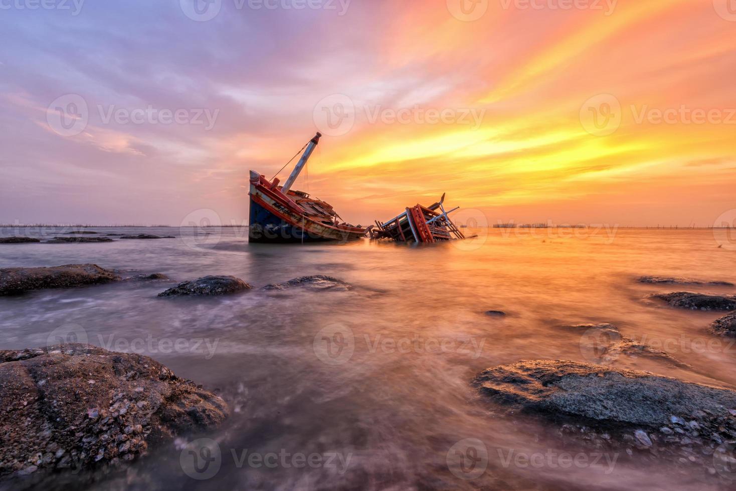 bateau de pêche échoué avec vue sur le coucher du soleil photo