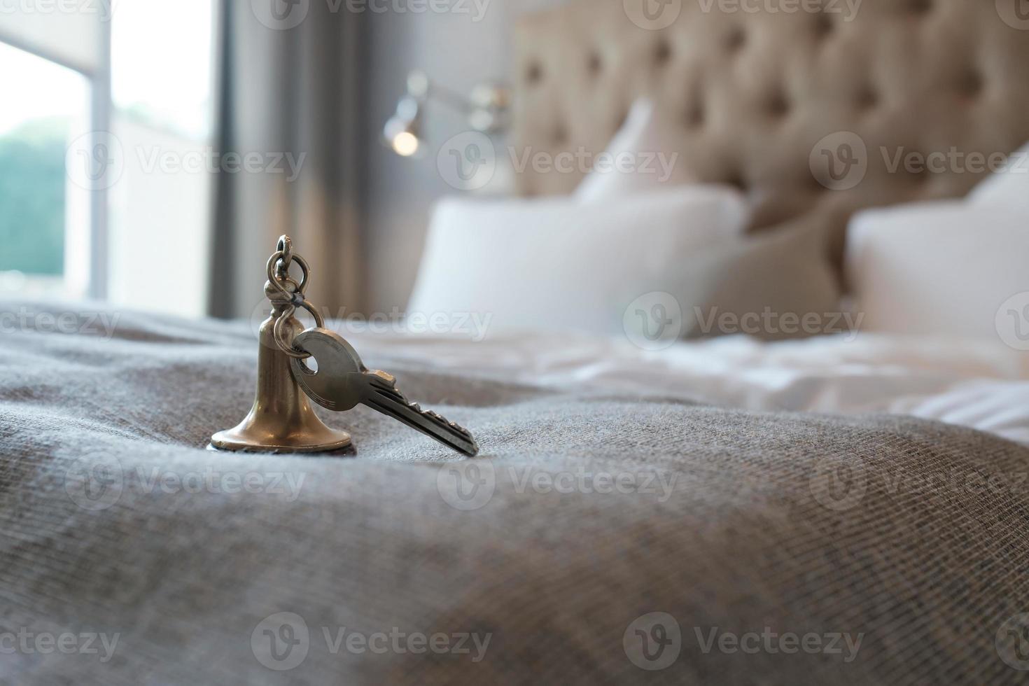 clé avec un porte-clés de la chambre d'hôtel se trouve sur le lit. photo