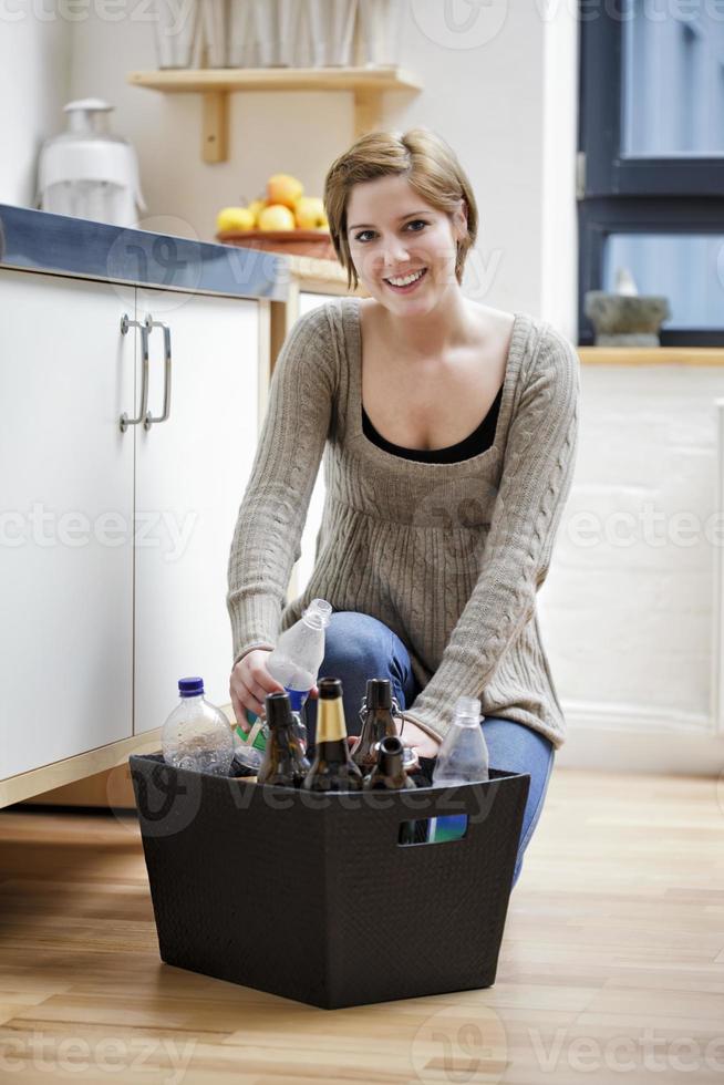 jeune femme, lecture, étiquettes, sur, bouteille recyclable photo