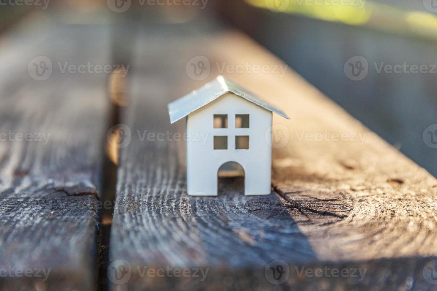 maison modèle miniature de jouet blanc sur fond de bois. village écologique, arrière-plan environnemental abstrait photo