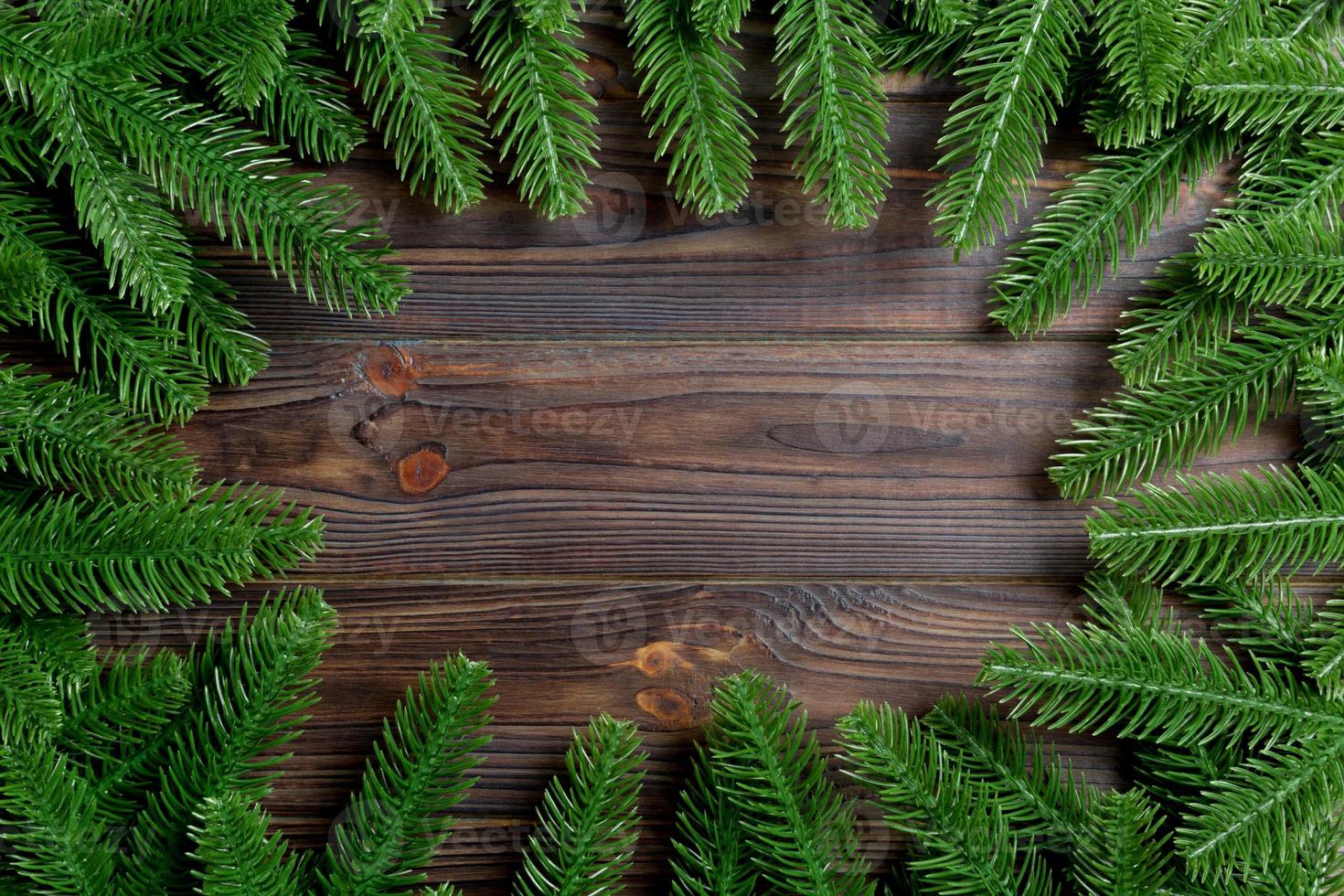 vue de dessus du cadre fait de branches de sapin sur fond de bois. concept de noël avec un espace vide pour votre conception photo