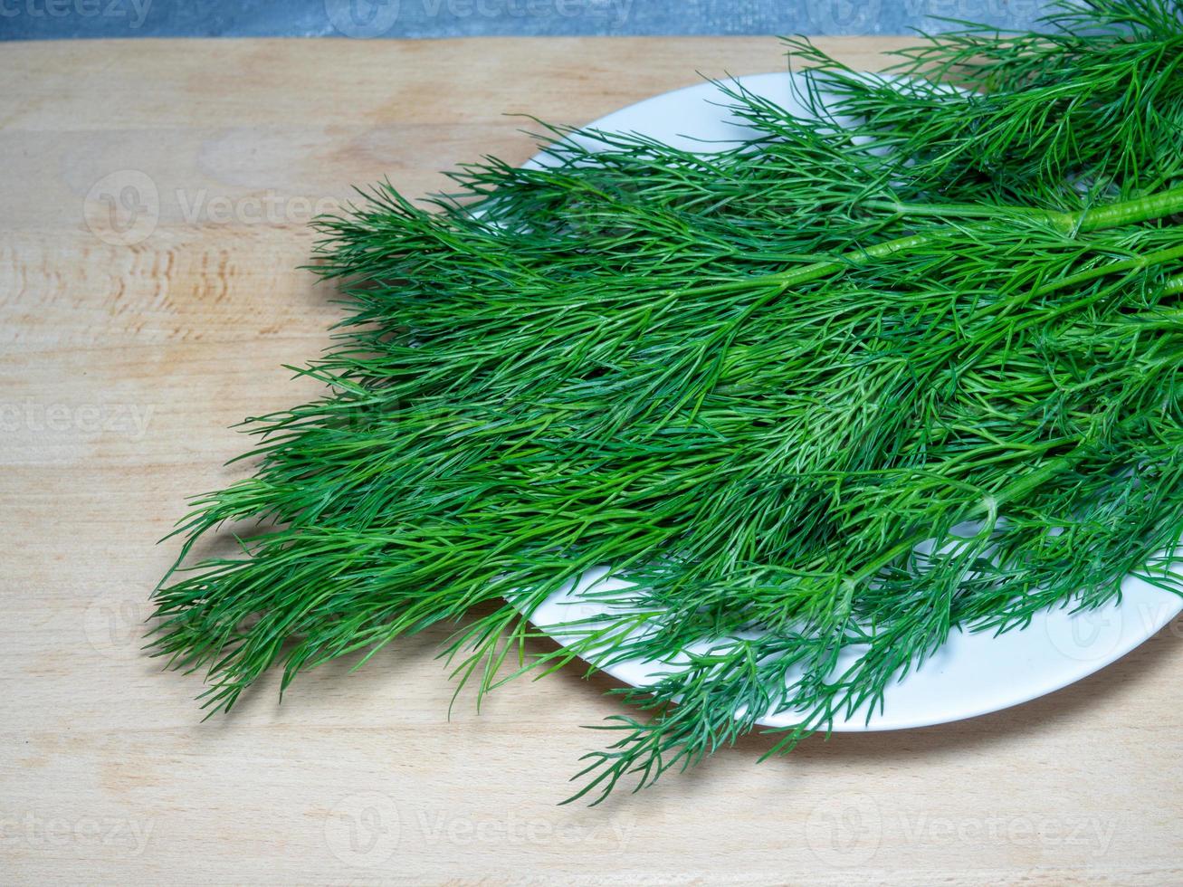 un bouquet d'aneth sur une planche à découper. produit utile. verts sur la table de la cuisine. ingrédient de déjeuner végétarien. photo