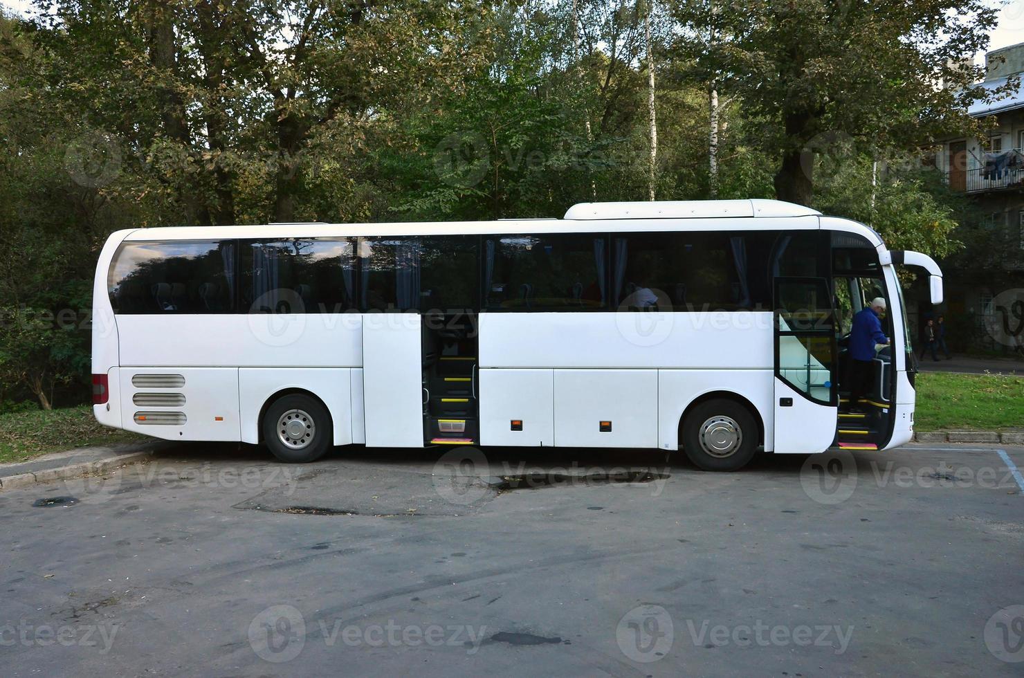 bus touristique blanc pour les excursions. le bus est garé dans un parking près du parc photo