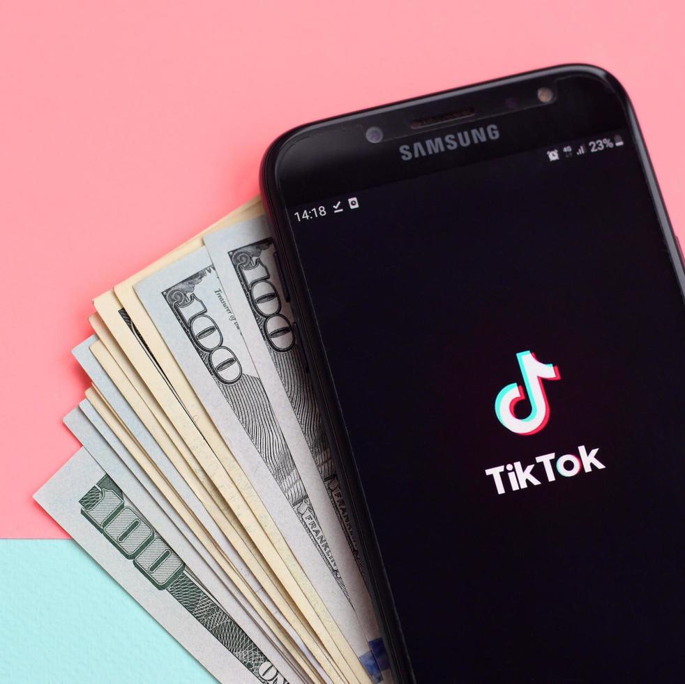 kharkov, ukraine - 3 mai 2022 application tiktok sur l'écran du smartphone samsung et les billets en dollars. tiktok est un service de réseau social de partage de vidéos populaire appartenant à bytedance photo