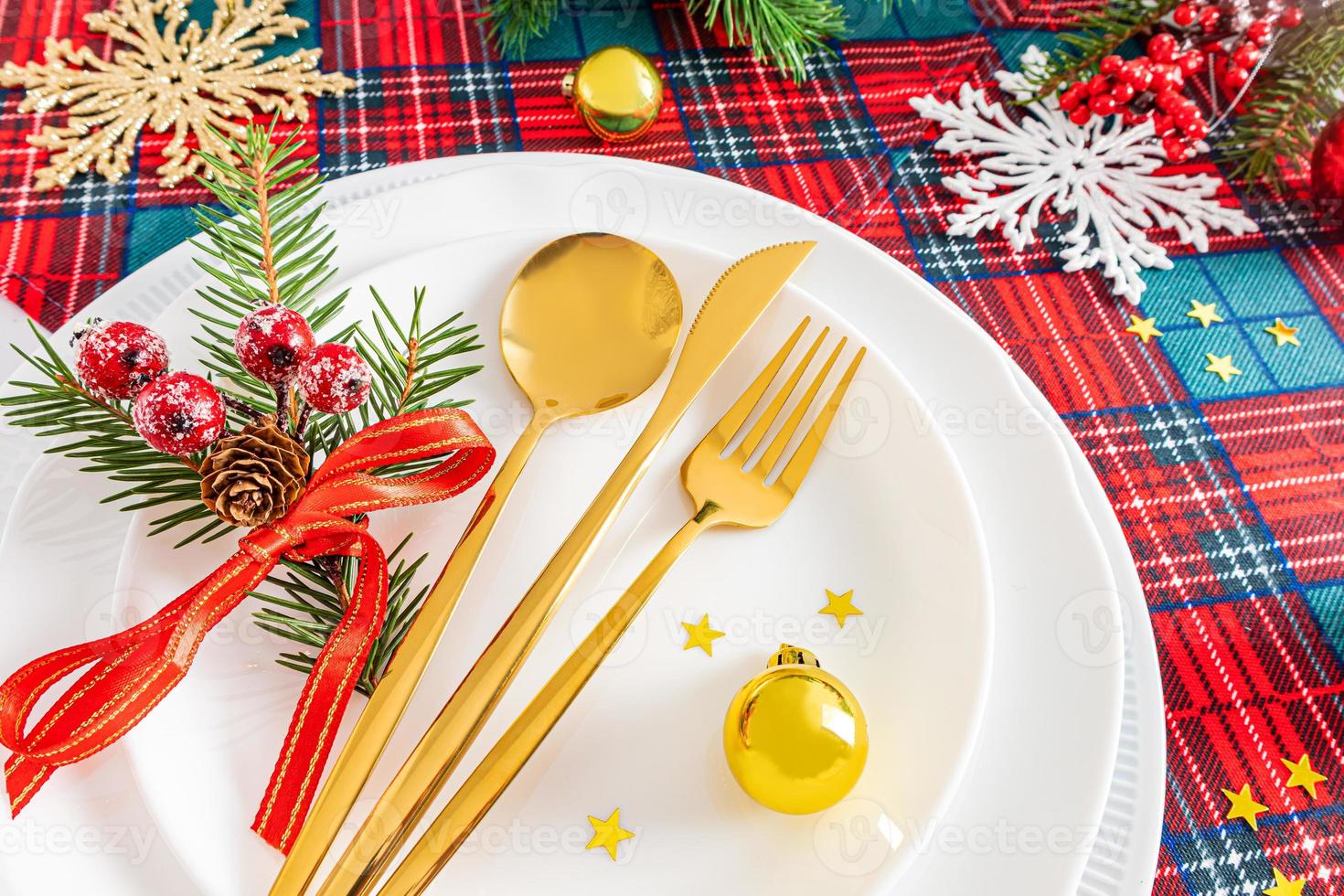service festif de la table de noël ou du nouvel an dans le style classique des tons rouges et blancs avec des branches d'épinette verte, décorations de noël. photo
