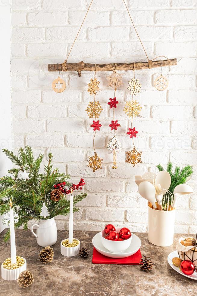 vue verticale d'un comptoir de cuisine moderne décoré pour le nouvel an et noël. guirlande maison sur un mur de briques blanches. photo