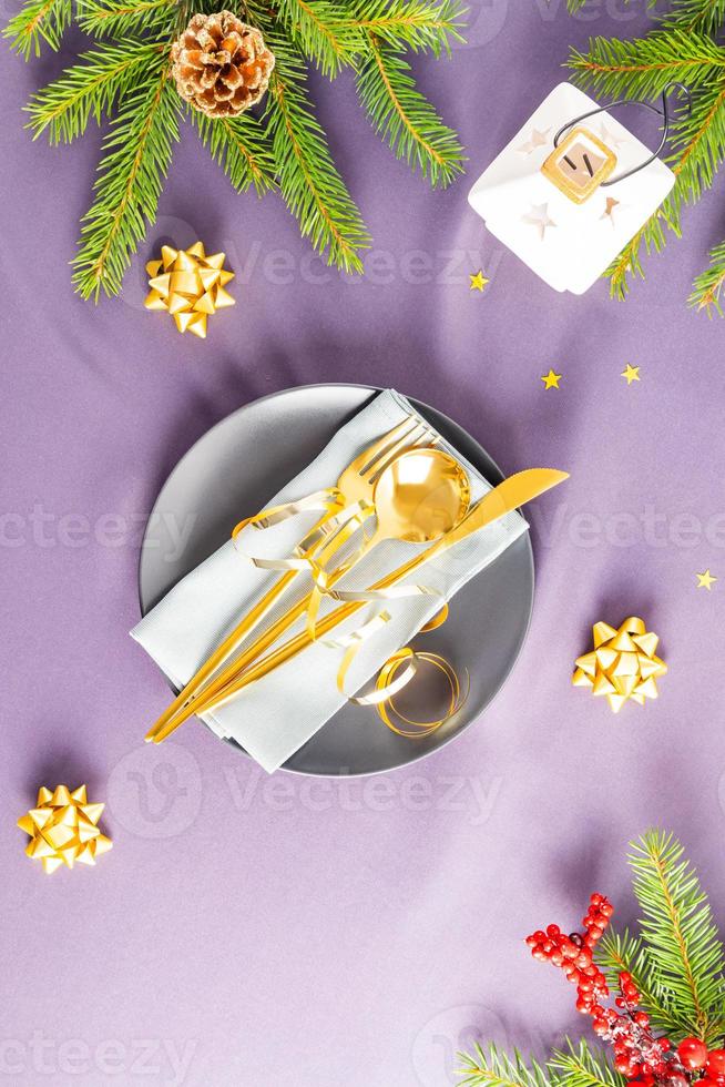 vue verticale de la table du nouvel an avec une assiette de service festive et des décorations. le concept de préparation pour le nouvel an et noël. photo