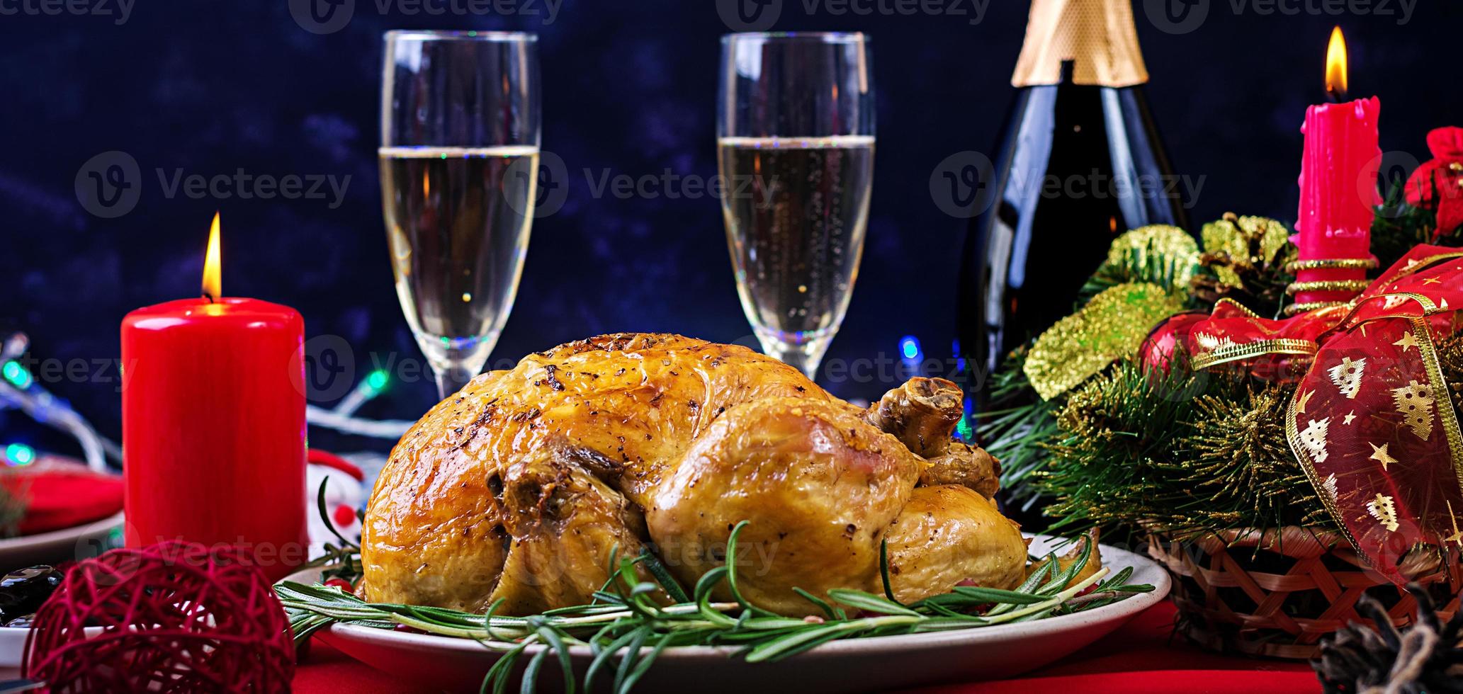 dinde au four. dîner de Noël. la table de noël est servie avec une dinde, décorée de guirlandes lumineuses et de bougies. poulet frit, table. dîner de famille. photo