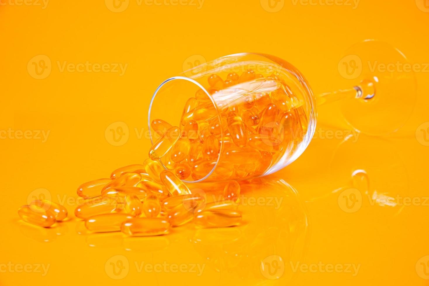 gélules d'huile de poisson. Comprimés jaunes d'oméga 3 en pot sur le jaune et l'orange. capsules d'huile de poisson en verre . en pot. en ampoules seau photo