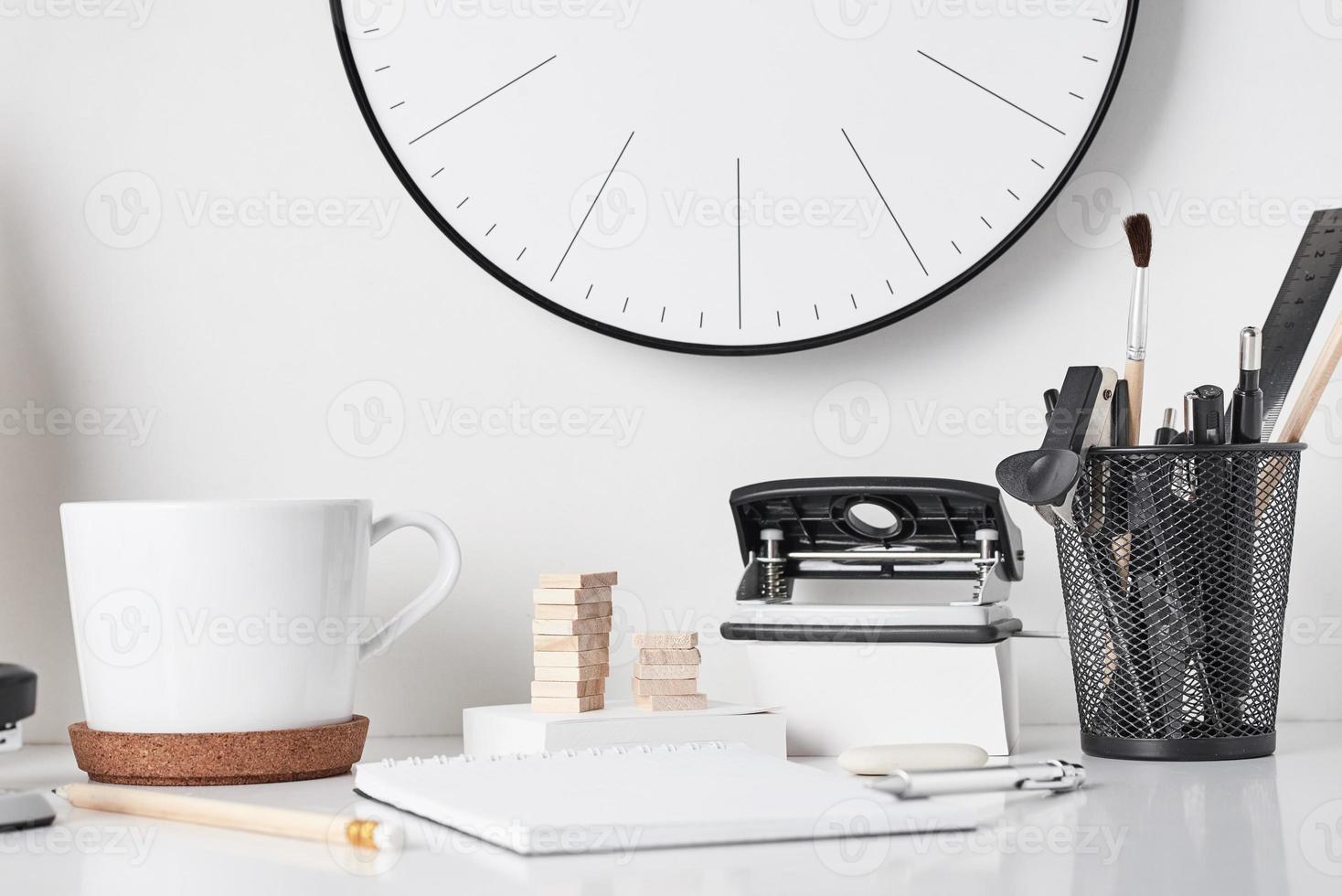 fournitures de bureau et horloge murale sur blanc photo