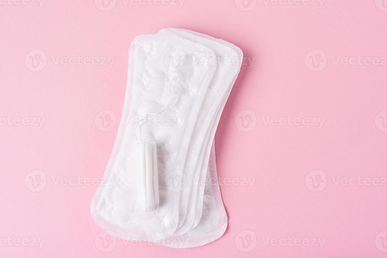 serviette hygiénique et tampon menstruel sur fond rose photo