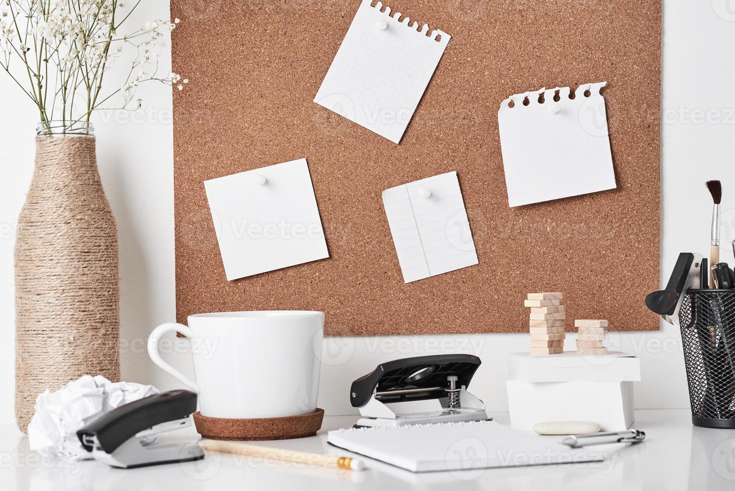 panneau de liège avec des fournitures de bureau sur fond blanc photo