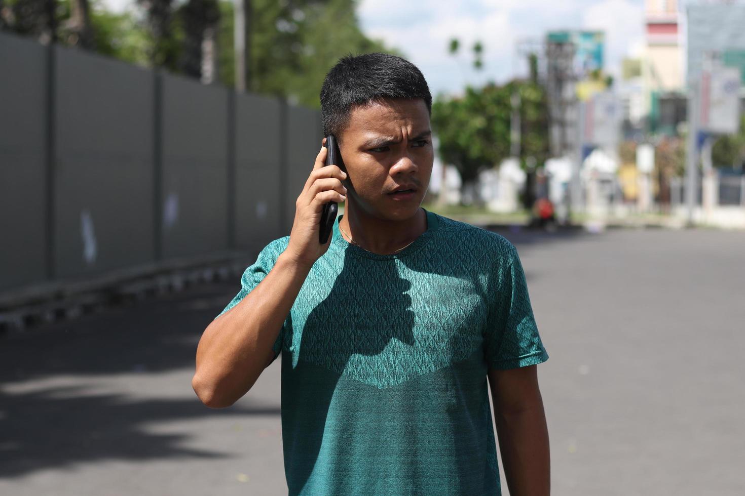 jeune garçon asiatique s'échauffant pour faire du jogging le matin et appelant son amie photo