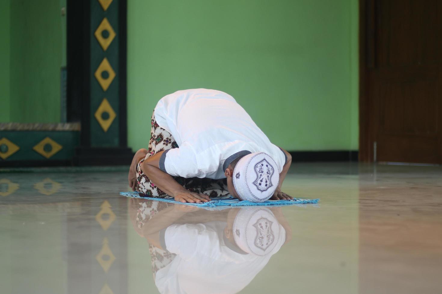 jeune musulman asiatique priant dans la mosquée photo