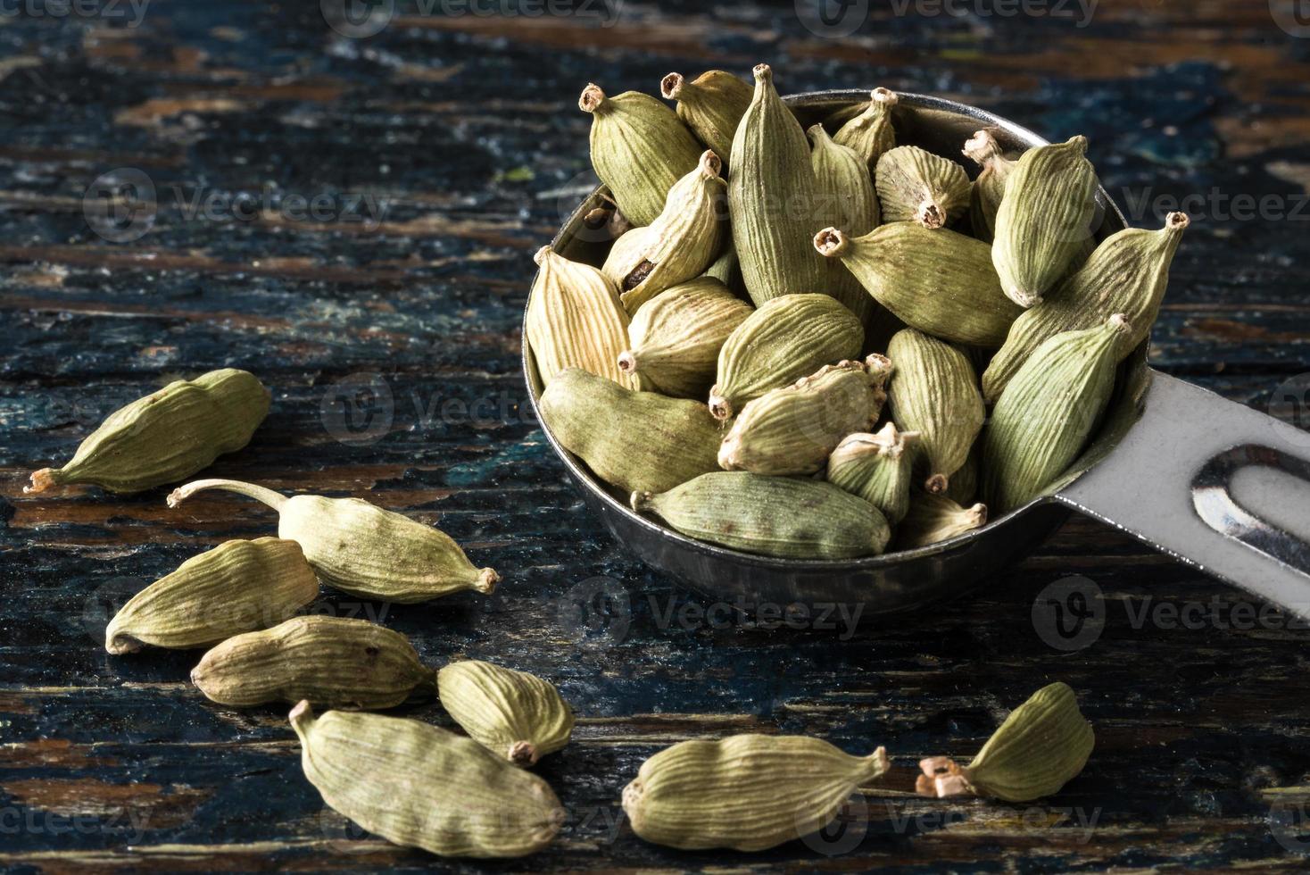 gousses de cardamome verte renversées d'une cuillère à café photo