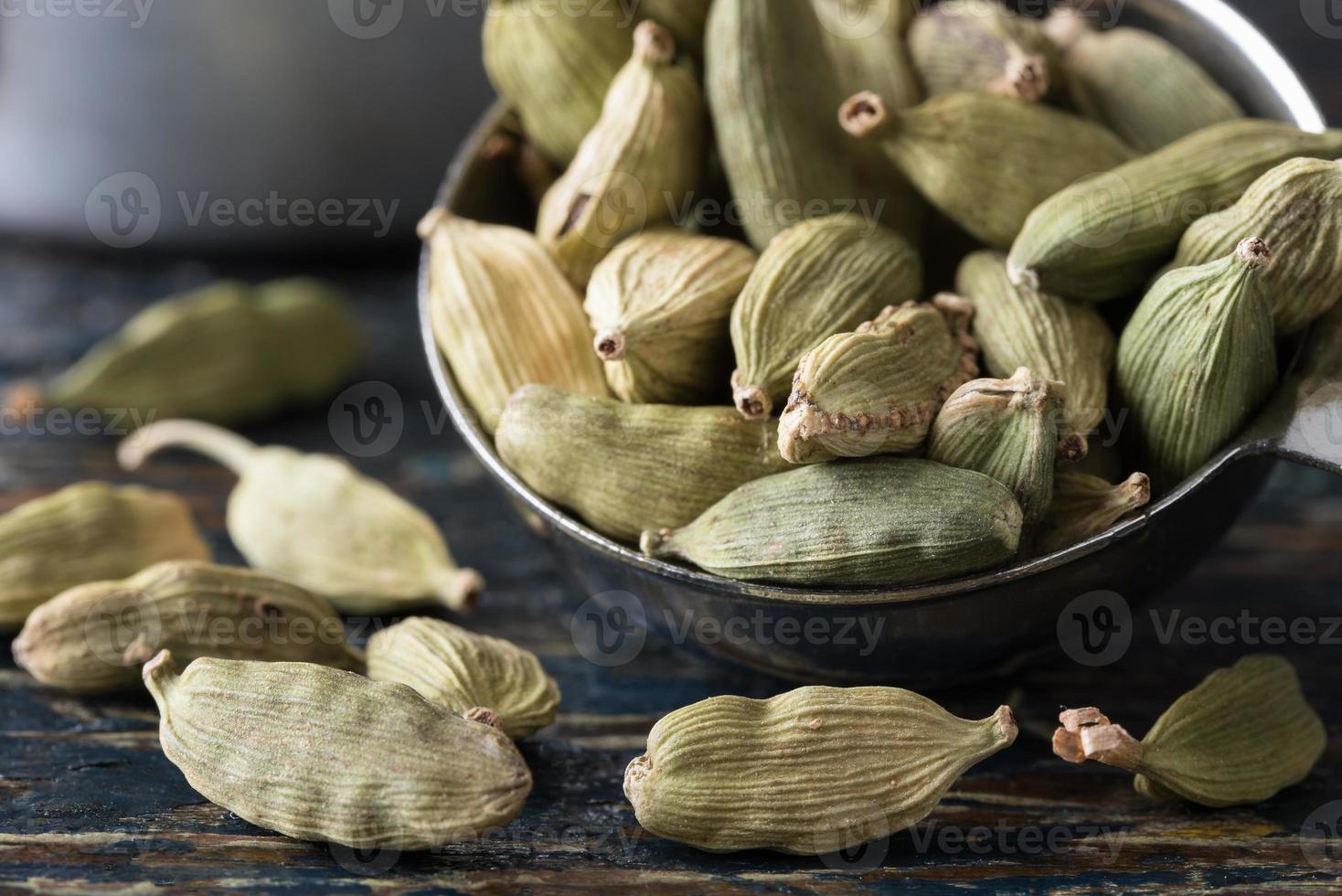 gousses de cardamome verte renversées d'une cuillère à café photo