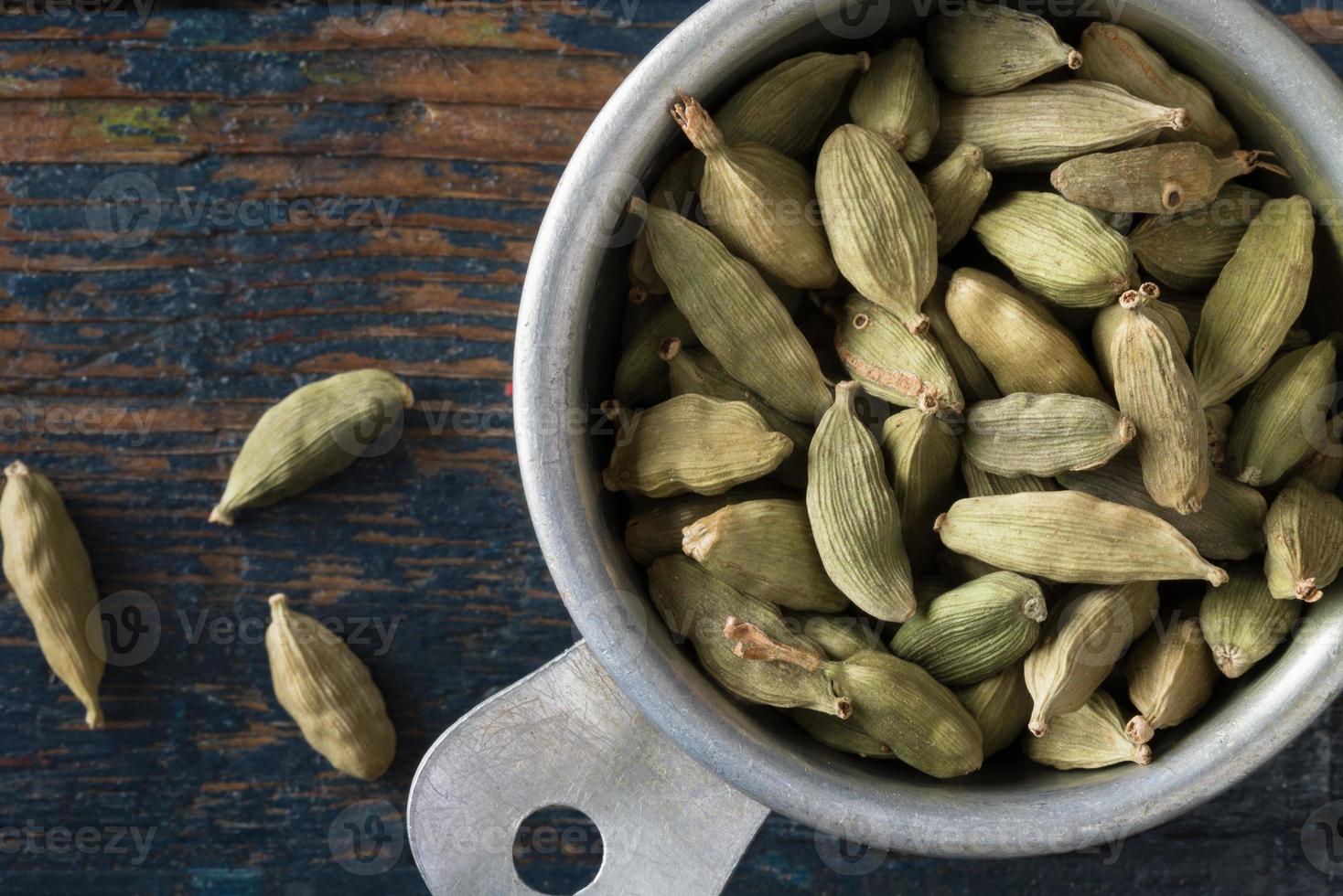 gousses de cardamome verte dans une tasse à mesurer photo