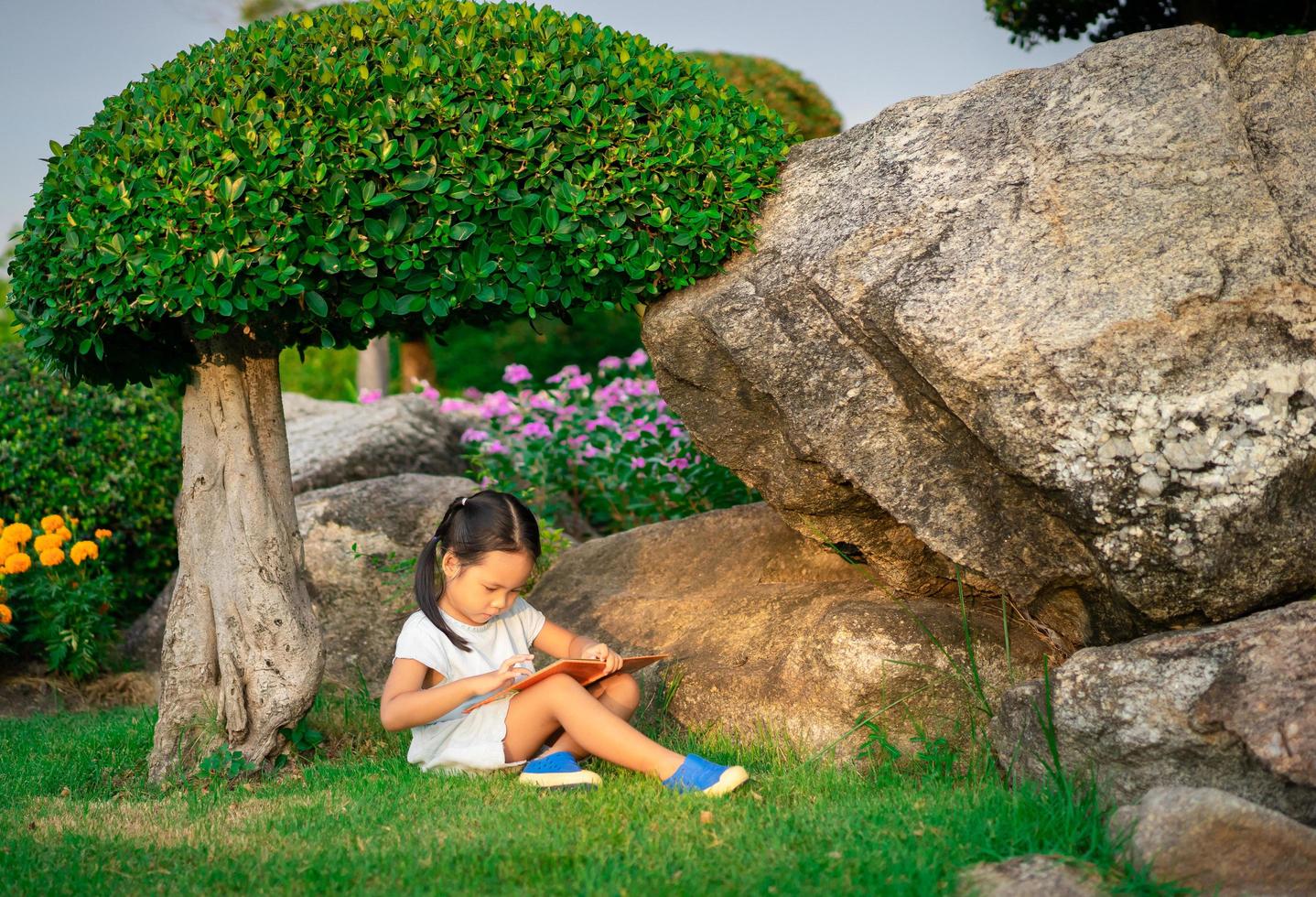 une petite fille mignonne en lisant un livre photo