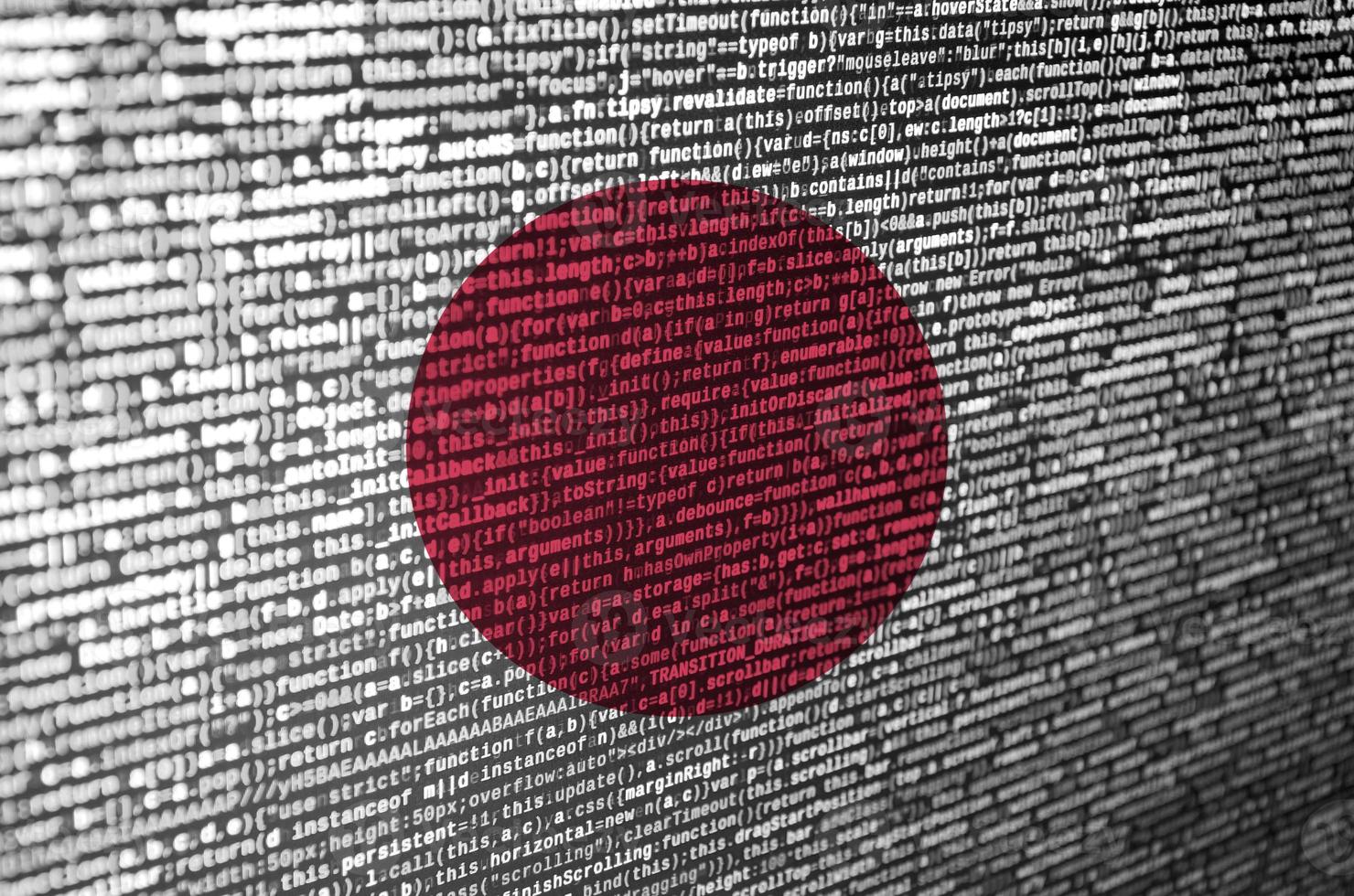 le drapeau japonais est représenté sur l'écran avec le code du programme. le concept de technologie moderne et de développement de site photo