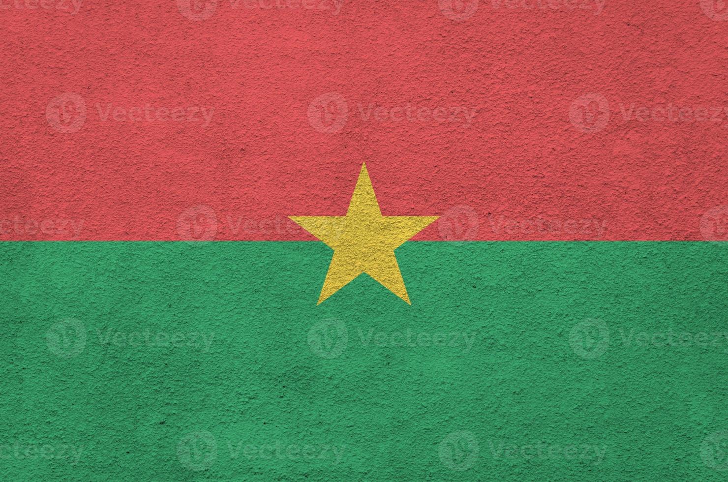 drapeau du burkina faso représenté dans des couleurs de peinture vives sur un vieux mur de plâtrage en relief. bannière texturée sur fond rugueux photo