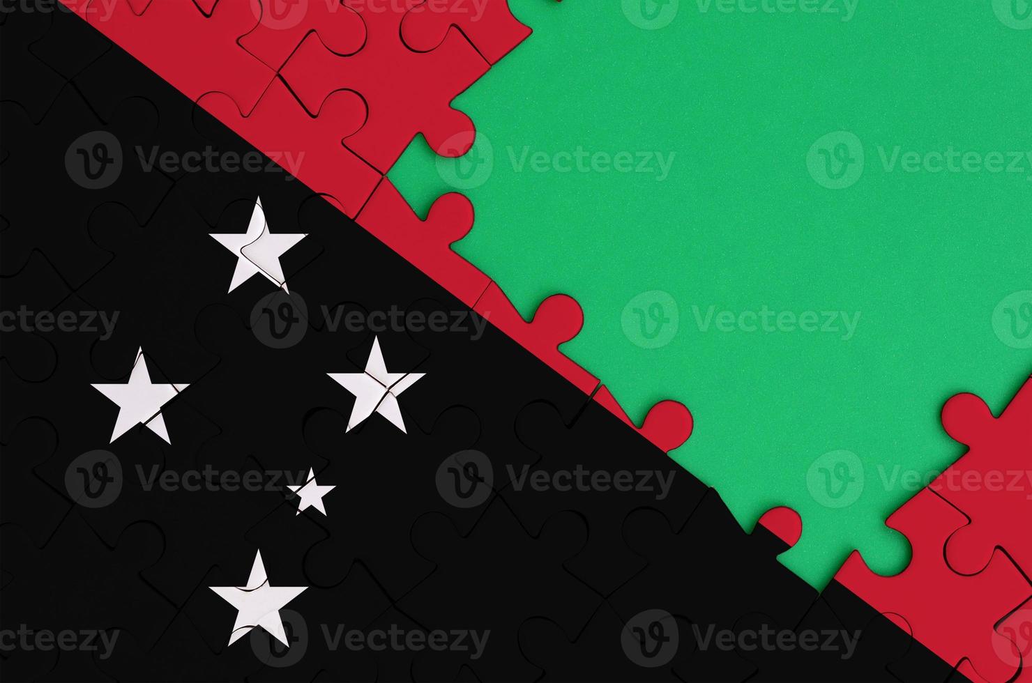 le drapeau de la papouasie-nouvelle-guinée est représenté sur un puzzle terminé avec un espace de copie vert gratuit sur le côté droit photo