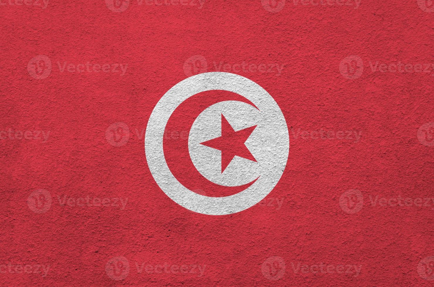 drapeau tunisien représenté dans des couleurs de peinture vives sur un vieux mur de plâtrage en relief. bannière texturée sur fond rugueux photo