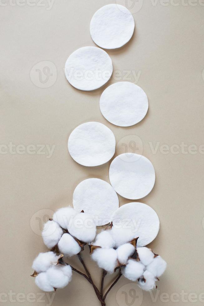tampons de coton fleur de coton moelleux sur fond beige avec espace de copie. produit jetable hygiénique photo