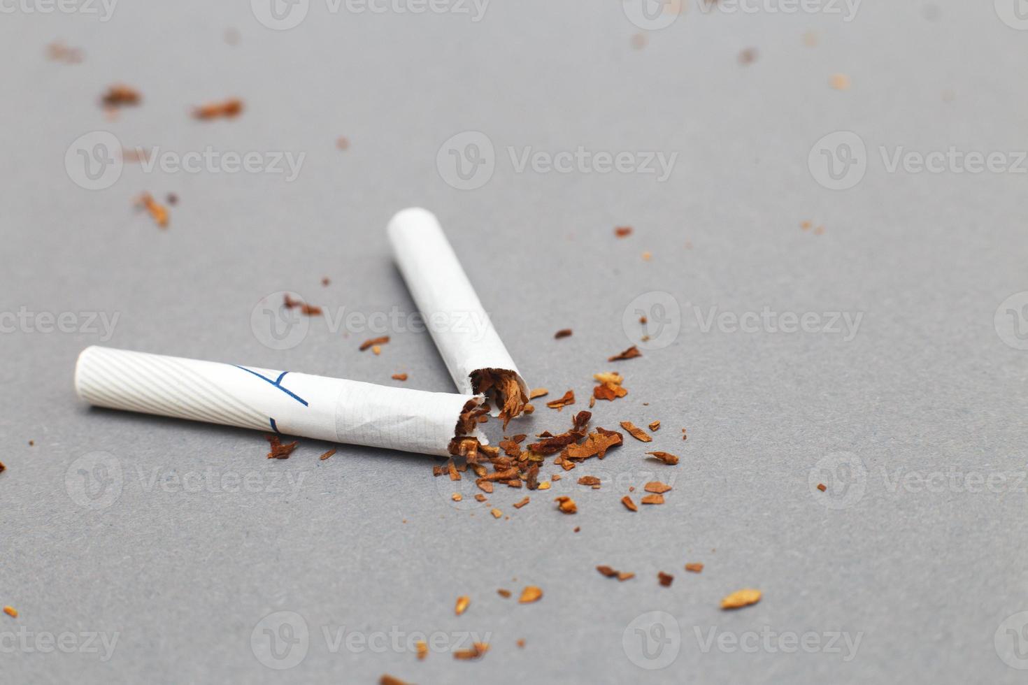 cigarette cassée sur fond gris à proximité. arrêter de fumer photo