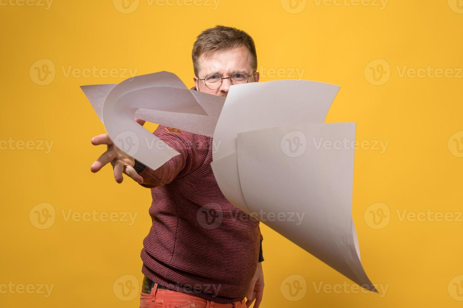 un homme stressé et en colère jette une pile de papier blanc vers l'avant. mauvaise journée de travail. notion psychologique. photo