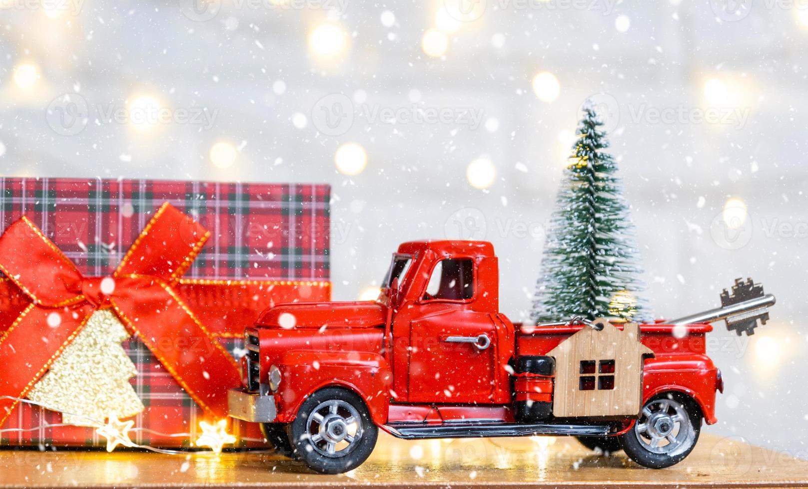 voiture rétro rouge avec un arbre de noël décore avec la clé de la maison dans la camionnette pour noël. achat d'une maison, déménagement, hypothèque, prêt, immobilier, ambiance festive, nouvel an photo