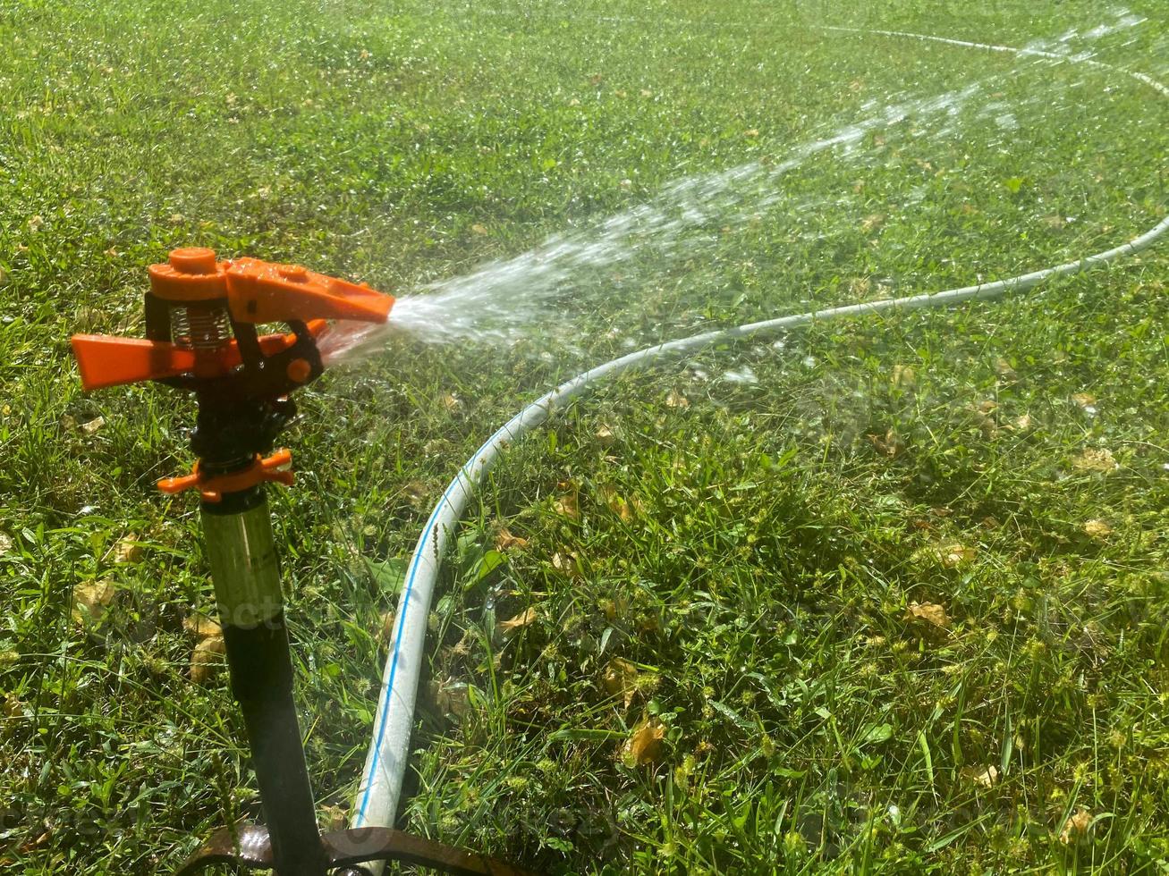 arroseur automatique d'herbe verte, pulvérisateur d'eau pour arroser les plantes de pelouse photo