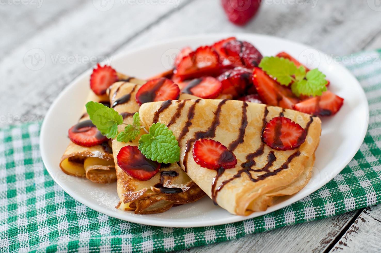 crêpes aux fraises et au chocolat décorées de feuilles de menthe photo