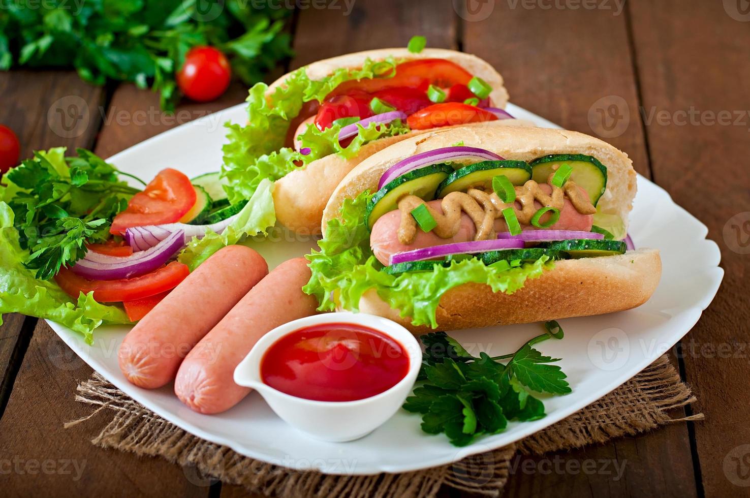 Hot-Dog avec du ketchup, de la moutarde, de la laitue et des légumes sur une table en bois photo