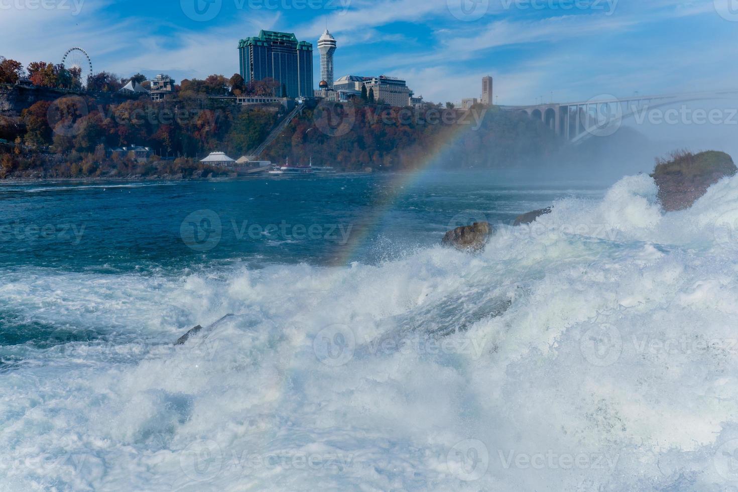 les chutes du niagara du côté américain et canadien. arc-en-ciel au-dessus de la cascade. l'endroit touristique le plus populaire. rivière orageuse qui se jette dans le lac. photo