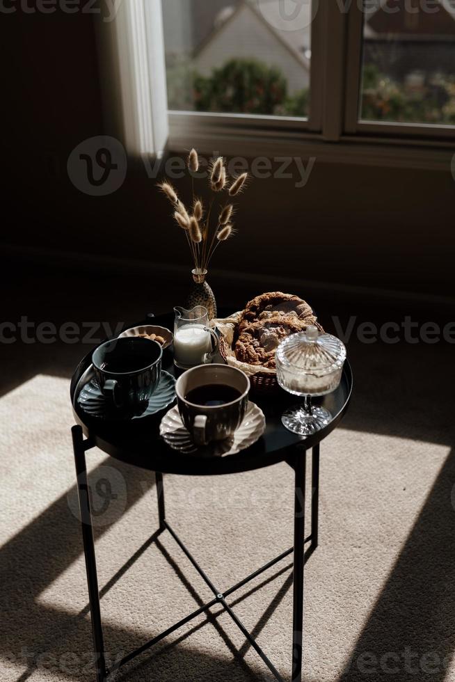 petit déjeuner esthétique. café au lait, thé au lait, sucre, amandes, gâteaux aux amandes, biscuits, massepains et choux. petit-déjeuner britannique dans une maison confortable. ambiance d'automne. photo