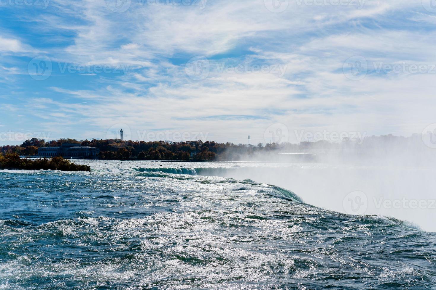 les chutes du niagara du côté américain et canadien. arc-en-ciel au-dessus de la cascade. l'endroit touristique le plus populaire. rivière orageuse qui se jette dans le lac. photo