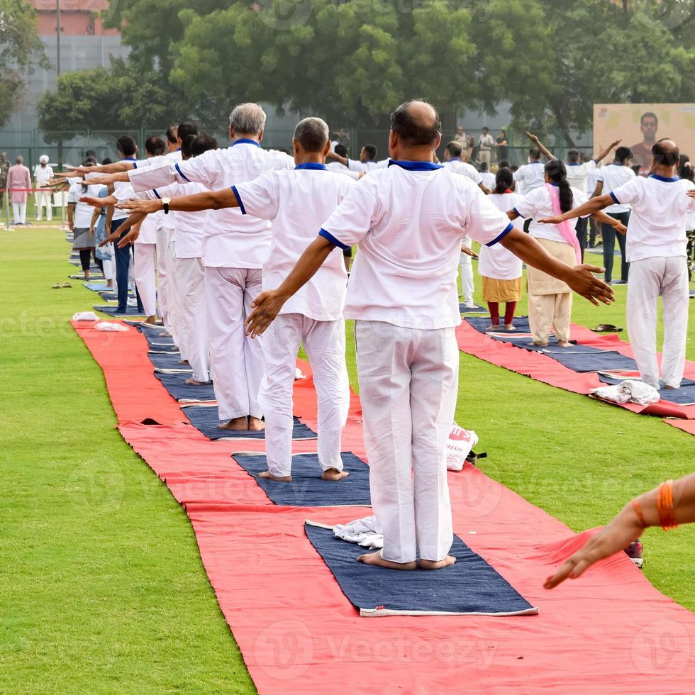 séance d'exercices de yoga en groupe pour les personnes de différents groupes d'âge au stade de cricket de delhi lors de la journée internationale du yoga, grand groupe d'adultes assistant à une séance de yoga photo