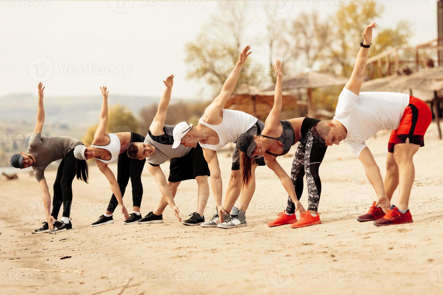 groupe d'amis faisant de l'exercice sur la plage photo