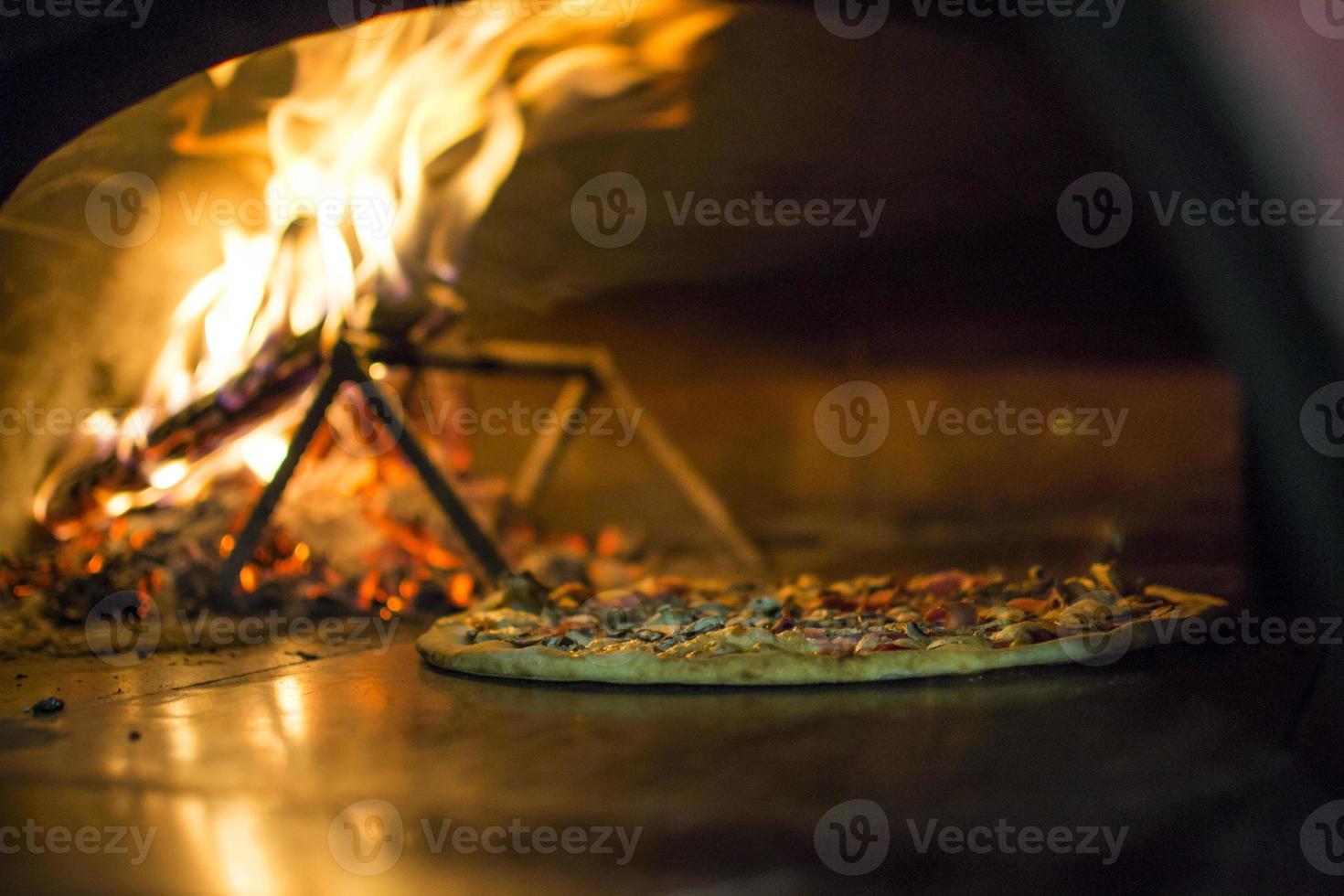 pizza près du poêle en pierre avec feu. arrière-plan d'un restaurant pizzeria traditionnel avec une cheminée. photo